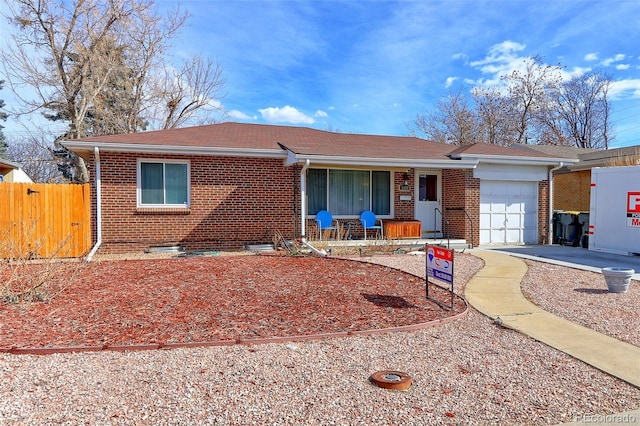 single story home featuring a garage, brick siding, and fence