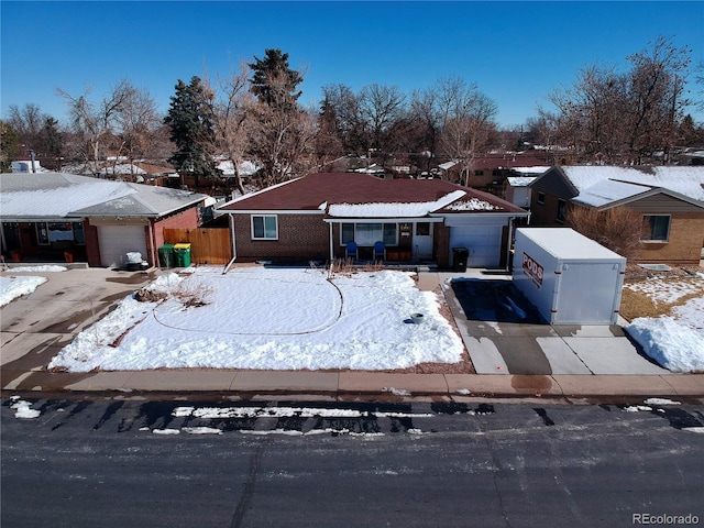 ranch-style house featuring a garage, a residential view, concrete driveway, and brick siding