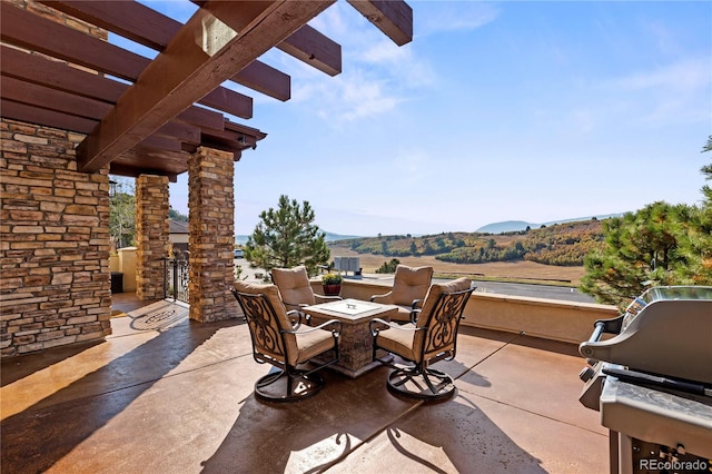 view of patio / terrace with outdoor dining area, a pergola, and a mountain view