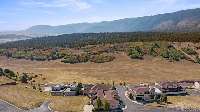 aerial view with a wooded view, a mountain view, and a residential view