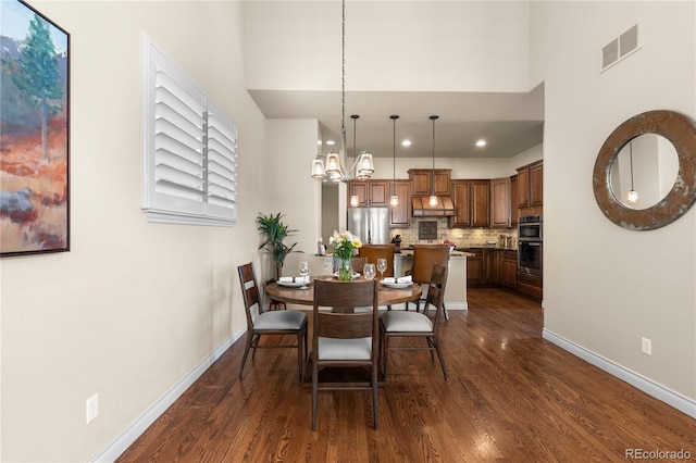 dining room with baseboards, visible vents, a chandelier, and dark wood finished floors