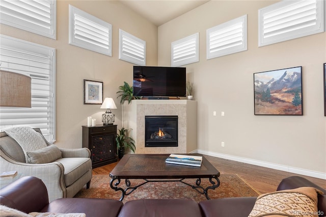 living room with baseboards, a fireplace, and wood finished floors