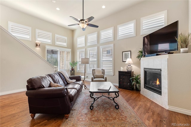 living room with recessed lighting, baseboards, a ceiling fan, a fireplace, and wood finished floors