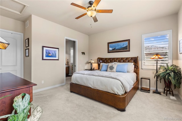 bedroom featuring baseboards, ensuite bathroom, visible vents, and light carpet