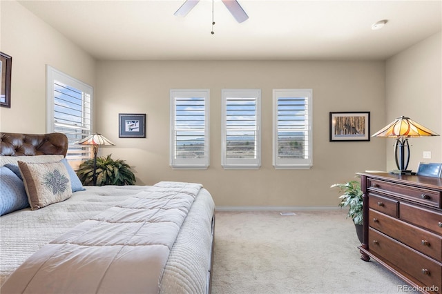 bedroom featuring multiple windows, baseboards, carpet flooring, and a ceiling fan
