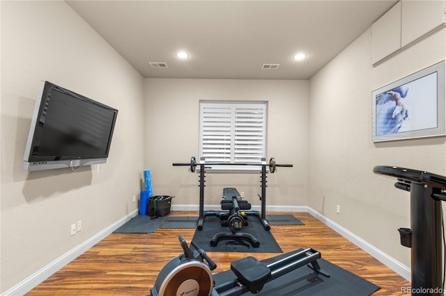 exercise area featuring baseboards, visible vents, recessed lighting, and wood finished floors