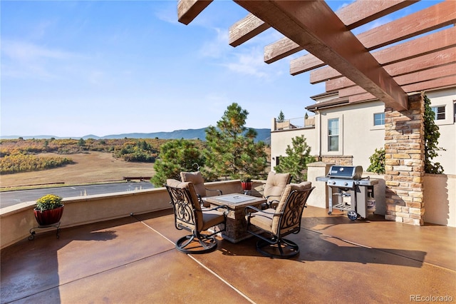 view of patio featuring area for grilling, a pergola, and a mountain view