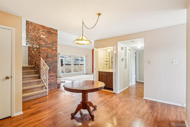 interior space with baseboards, light wood finished floors, and stairs