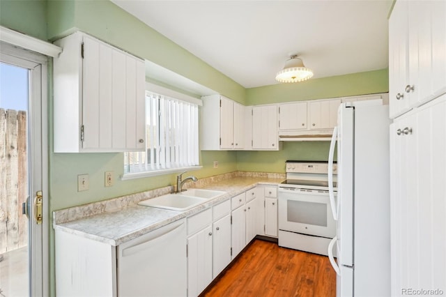 kitchen with dark wood finished floors, white appliances, white cabinets, and a sink