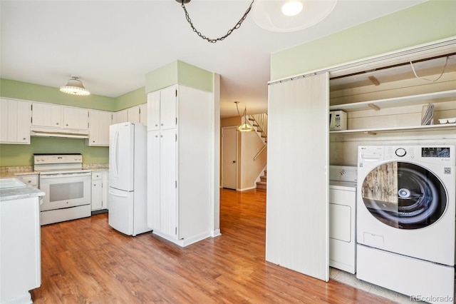 clothes washing area featuring laundry area, washer / clothes dryer, and light wood-type flooring