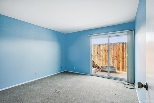 unfurnished room featuring carpet and baseboards