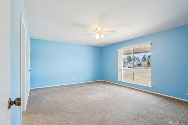 carpeted empty room with ceiling fan and baseboards