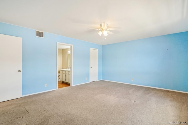 unfurnished bedroom with carpet, connected bathroom, visible vents, and baseboards