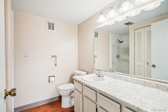 bathroom featuring toilet, a closet, vanity, and visible vents