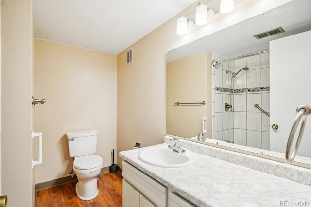 bathroom with toilet, a tile shower, and visible vents