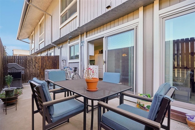 view of patio / terrace with outdoor dining area, a grill, and fence