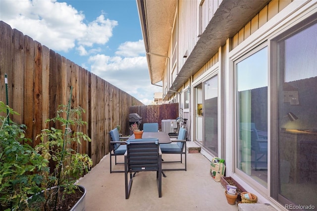 view of patio with outdoor dining area, a fenced backyard, and central air condition unit