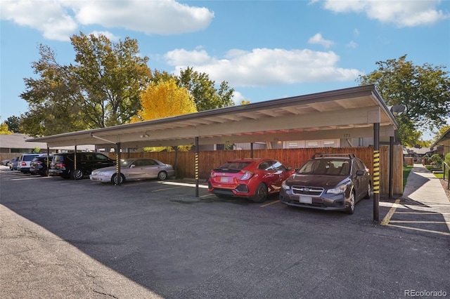 covered parking lot featuring fence