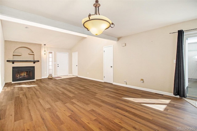 unfurnished living room featuring visible vents, a large fireplace, baseboards, and wood finished floors