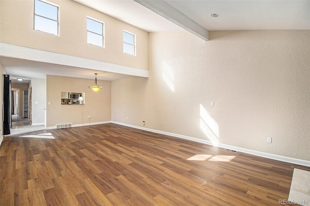 unfurnished living room with visible vents, baseboards, and wood finished floors