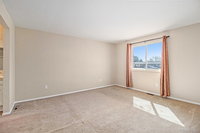 carpeted empty room featuring visible vents and baseboards