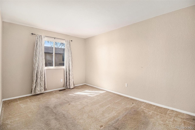 carpeted empty room with visible vents and baseboards