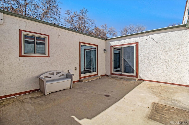 exterior space with a patio area and stucco siding