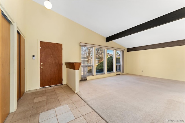 foyer entrance featuring beam ceiling, light colored carpet, high vaulted ceiling, and light tile patterned flooring