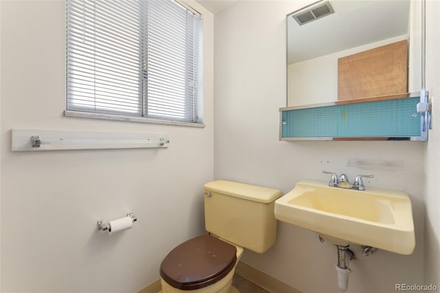 bathroom with visible vents, toilet, and a sink