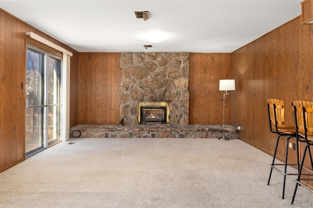 living area featuring wooden walls and carpet floors