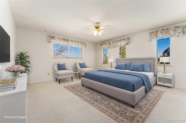 bedroom featuring light carpet, ceiling fan, and baseboards