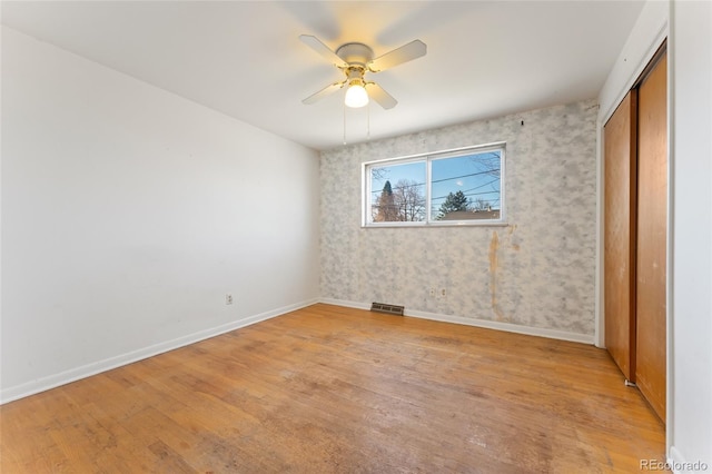 unfurnished bedroom with visible vents, baseboards, a closet, and light wood finished floors