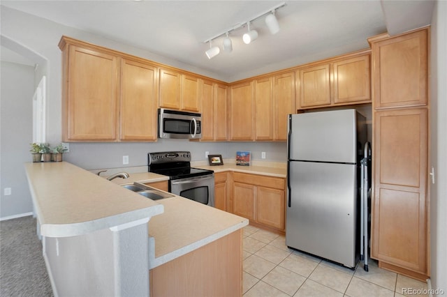 kitchen featuring stainless steel appliances, light brown cabinetry, and a peninsula