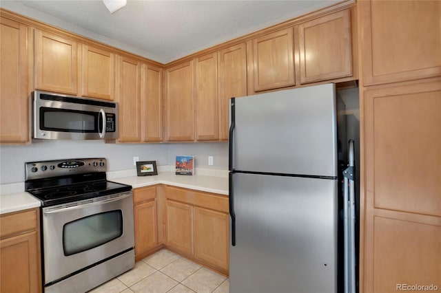 kitchen featuring appliances with stainless steel finishes, light countertops, light brown cabinets, and light tile patterned floors