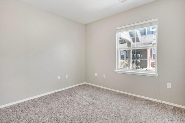 unfurnished room with carpet floors and baseboards