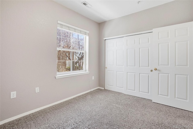 unfurnished bedroom featuring carpet floors, a closet, visible vents, and baseboards