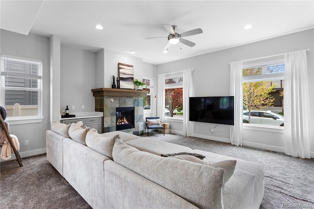 carpeted living area with a ceiling fan, baseboards, a fireplace, and recessed lighting
