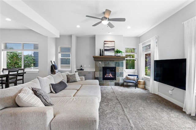 carpeted living area featuring healthy amount of natural light, ceiling fan, a tile fireplace, recessed lighting, and baseboards