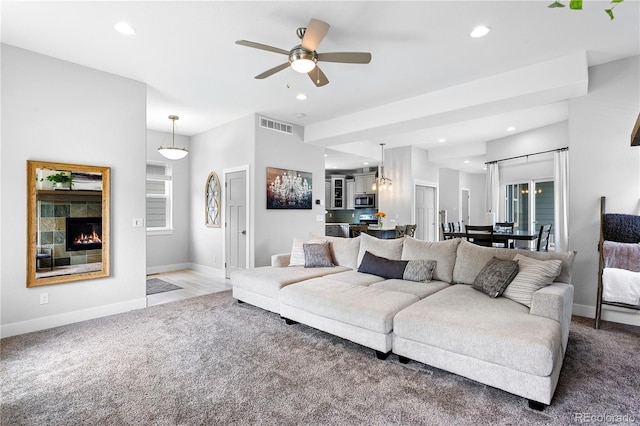carpeted living area with a tiled fireplace, a ceiling fan, baseboards, and recessed lighting
