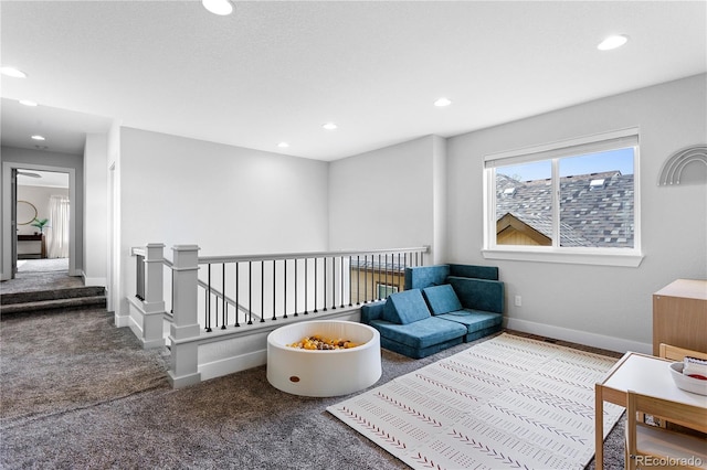 sitting room featuring carpet floors, baseboards, recessed lighting, and an upstairs landing