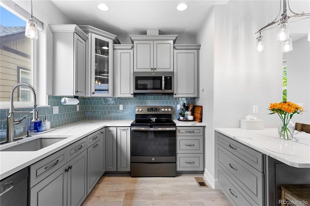 4589 Quandary Peak St, Brighton, CO 80601 - kitchen with appliances with stainless steel finishes, gray cabinets, a sink, tasteful backsplash, and recessed lighting