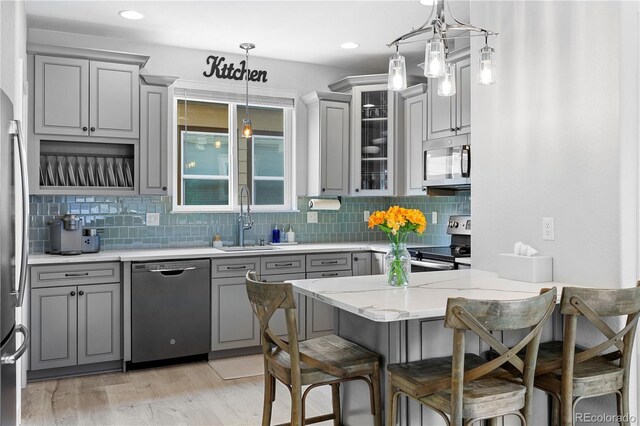 4589 Quandary Peak St, Brighton, CO 80601 - kitchen with appliances with stainless steel finishes, gray cabinetry, a sink, decorative backsplash, and recessed lighting