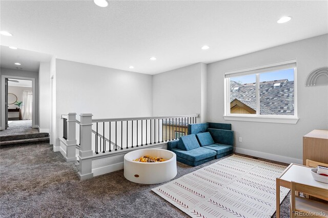 4589 Quandary Peak St, Brighton, CO 80601 - sitting room with carpet floors, an upstairs landing, and recessed lighting