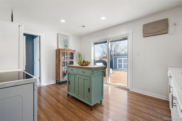 kitchen featuring green cabinets, white cabinets, white electric range, dark hardwood / wood-style floors, and a kitchen island