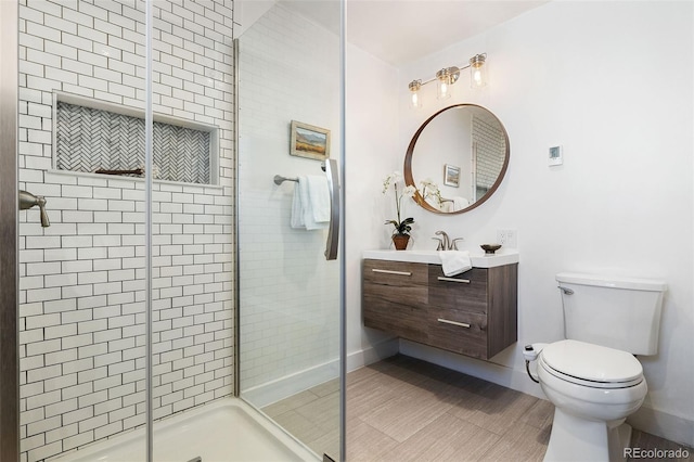 bathroom featuring toilet, an enclosed shower, and vanity