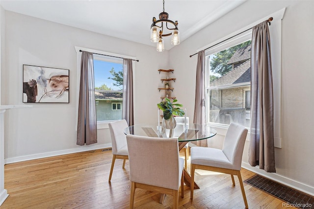 dining area featuring light wood-style floors, visible vents, and baseboards