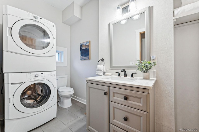 laundry area with laundry area, light tile patterned flooring, a sink, and stacked washer and clothes dryer