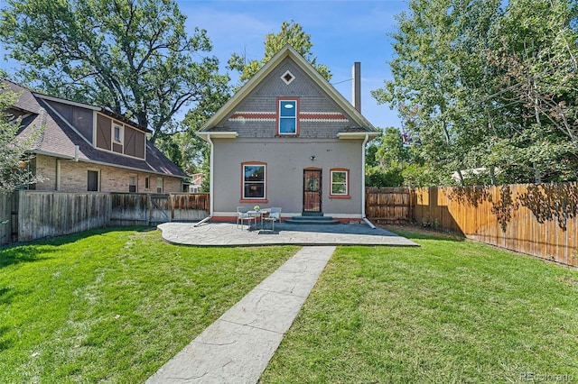 back of house with a patio, a lawn, and a fenced backyard