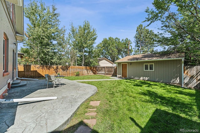 view of yard featuring an outbuilding, a patio, and a fenced backyard