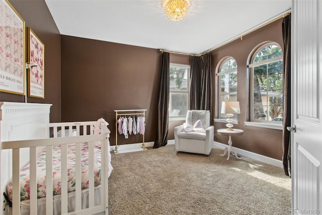 carpeted bedroom with a nursery area and baseboards